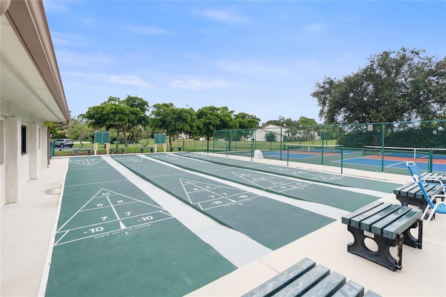 view of home's community featuring tennis court