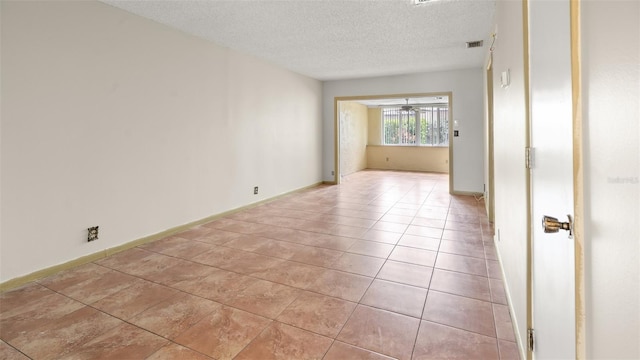 tiled spare room featuring a textured ceiling