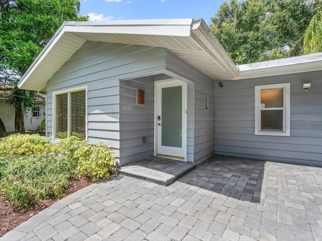 view of exterior entry with a patio