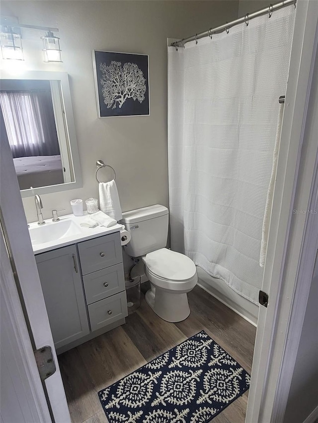 bathroom featuring a shower with curtain, hardwood / wood-style flooring, vanity, and toilet