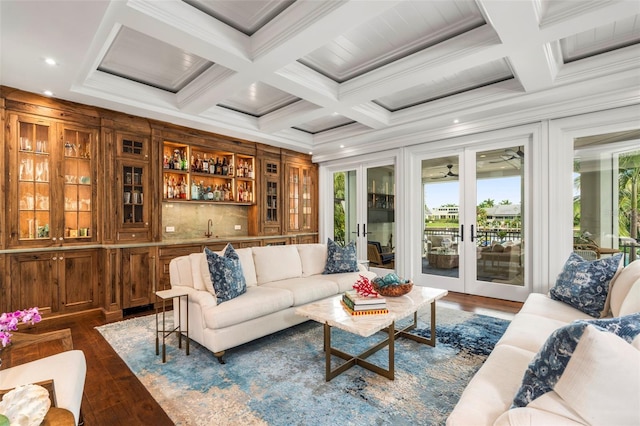 living room featuring crown molding, wet bar, beamed ceiling, and dark hardwood / wood-style flooring