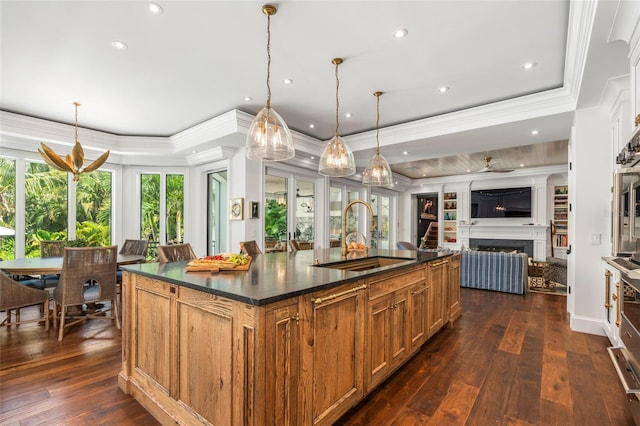 kitchen with hanging light fixtures, sink, a large island, dark hardwood / wood-style floors, and crown molding