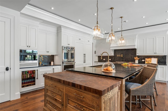 501 Harbor Point Rd, Longboat Key, FL 34228 - kitchen with wooden counters, wine cooler, an island with sink, stainless steel double oven, and dark wood-style flooring