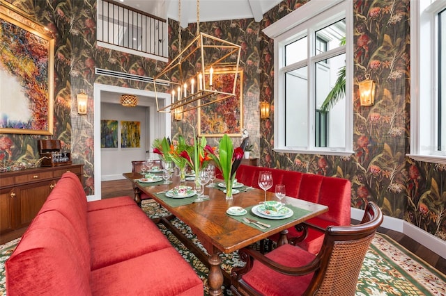 dining space with a notable chandelier, lofted ceiling with beams, and hardwood / wood-style flooring