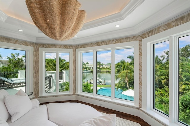 unfurnished sunroom featuring a raised ceiling and a water view