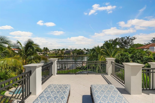 view of patio featuring a water view and a balcony