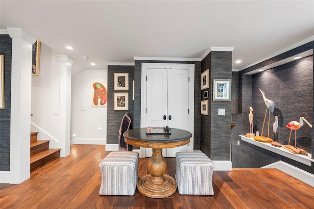 dining room featuring ornamental molding, wood-type flooring, and ornate columns