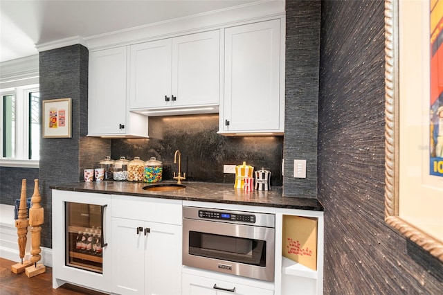 501 Harbor Point Rd, Longboat Key, FL 34228 - kitchen featuring a sink, decorative backsplash, beverage cooler, dark wood finished floors, and dark stone counters