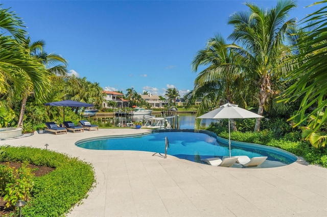 view of swimming pool with a patio and a water view