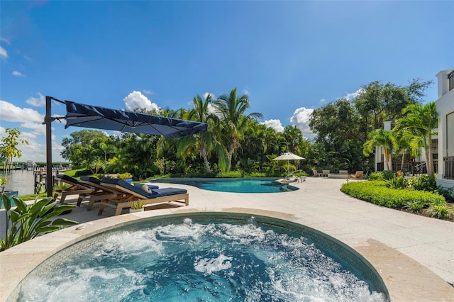 view of swimming pool featuring a patio and an in ground hot tub