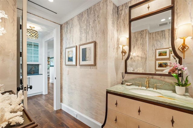 bathroom with wood-type flooring, vanity, and ornamental molding