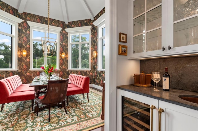 sunroom featuring wine cooler, bar, and lofted ceiling with beams