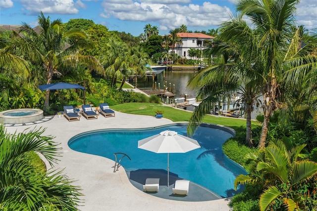 view of swimming pool featuring a yard, a water view, an in ground hot tub, and a patio area