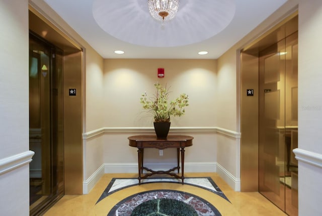 hallway with an inviting chandelier and elevator