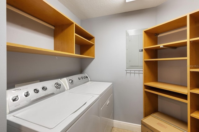 laundry room with a textured ceiling, electric panel, and separate washer and dryer