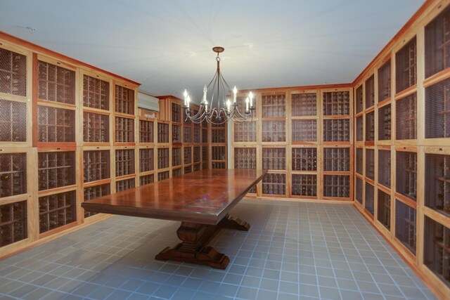 wine cellar featuring a notable chandelier, a wall mounted air conditioner, and tile patterned floors