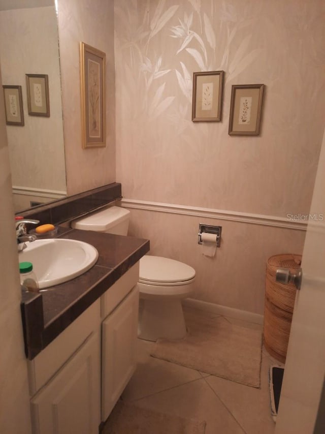 bathroom with vanity, toilet, and tile patterned floors