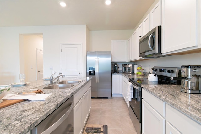 kitchen featuring white cabinetry, light tile patterned flooring, appliances with stainless steel finishes, and sink