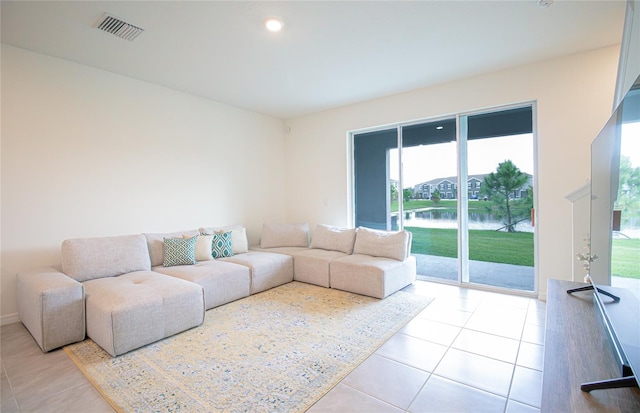 tiled living room featuring a water view