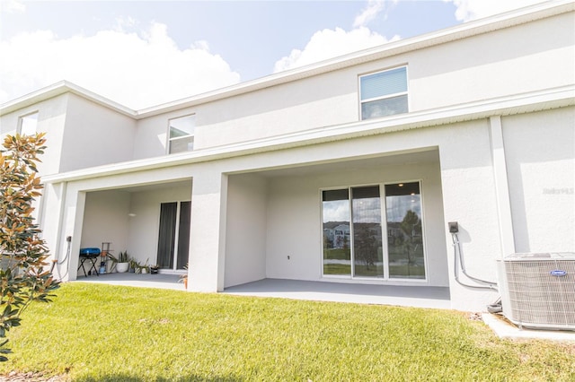 rear view of house featuring a patio area, central AC, and a lawn