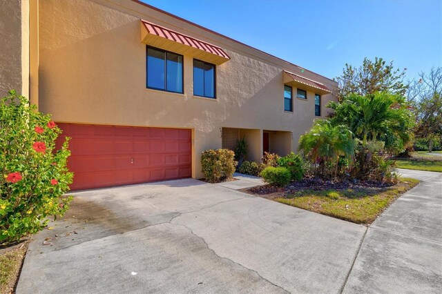 view of front of property featuring concrete driveway, a garage, and stucco siding