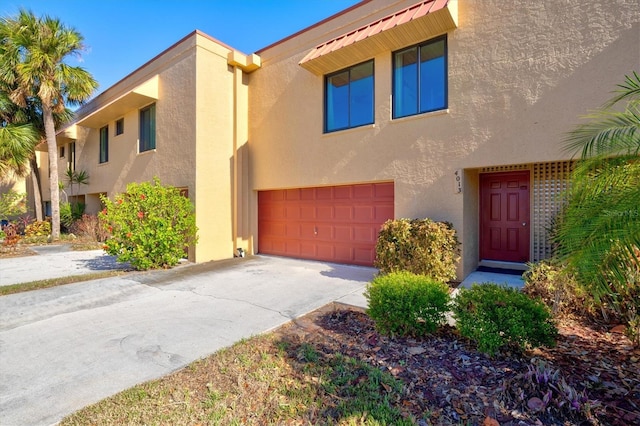 view of front of property with concrete driveway, a garage, and stucco siding
