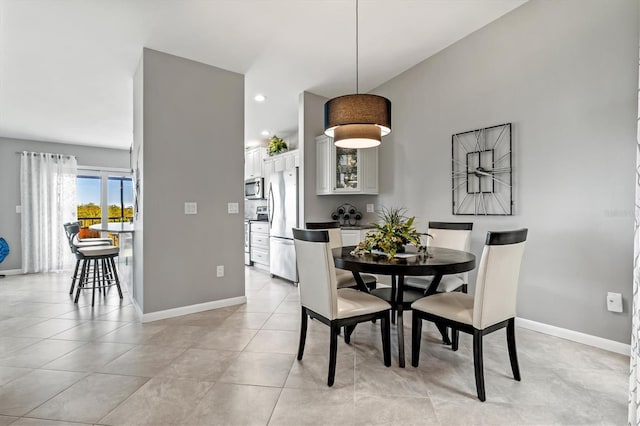 dining room featuring light tile patterned floors, baseboards, and recessed lighting