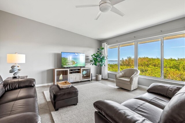 living room with ceiling fan, tile patterned flooring, and vaulted ceiling