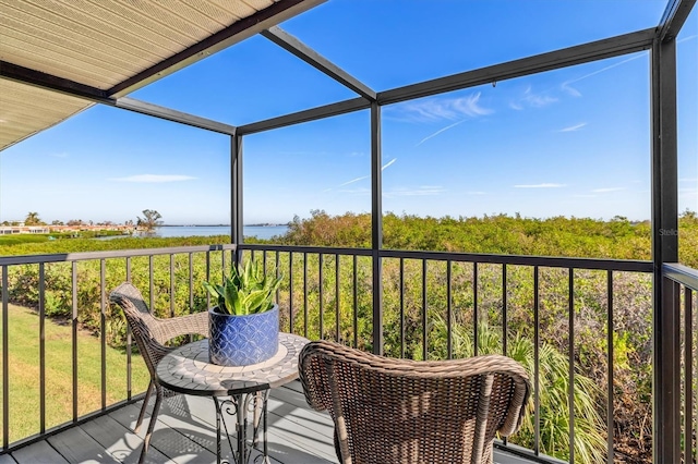 sunroom featuring a water view