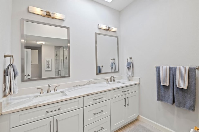 bathroom featuring double vanity, a shower stall, and a sink