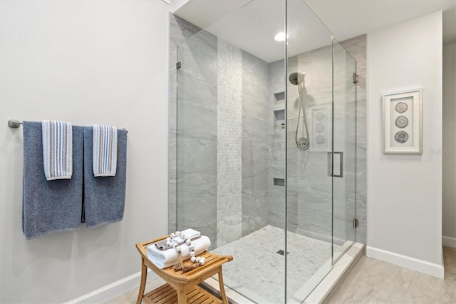 full bath with baseboards, a shower stall, and marble finish floor