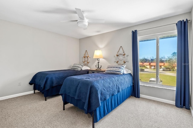 carpeted bedroom with baseboards, a ceiling fan, and multiple windows
