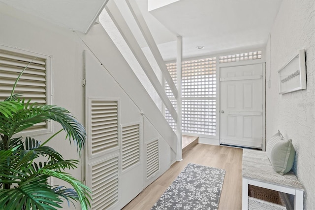 foyer with a textured wall and light wood-style flooring