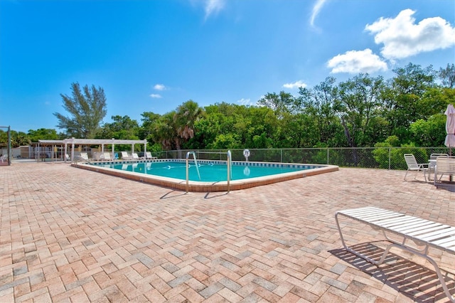 pool with a patio and fence