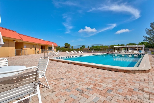 pool with a patio and fence