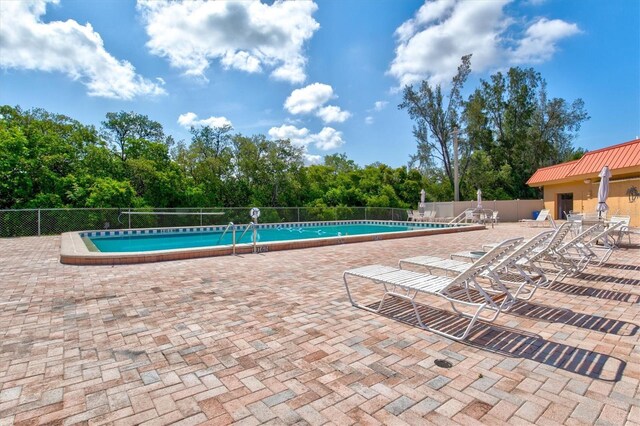 pool featuring fence and a patio