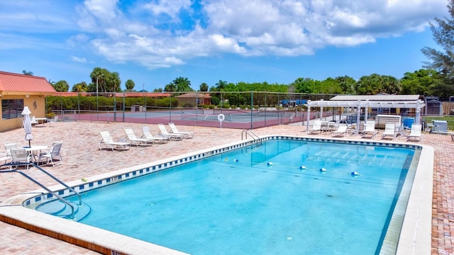 community pool featuring fence and a patio area
