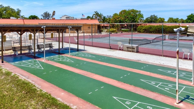 view of property's community featuring fence and shuffleboard