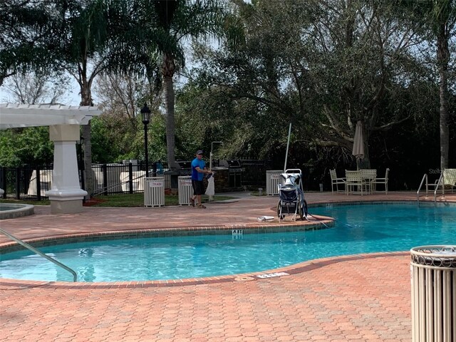 pool featuring fence, area for grilling, a pergola, and a patio