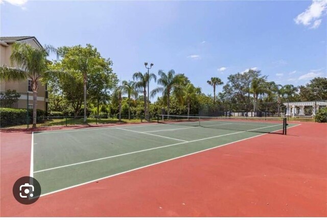 view of tennis court featuring fence