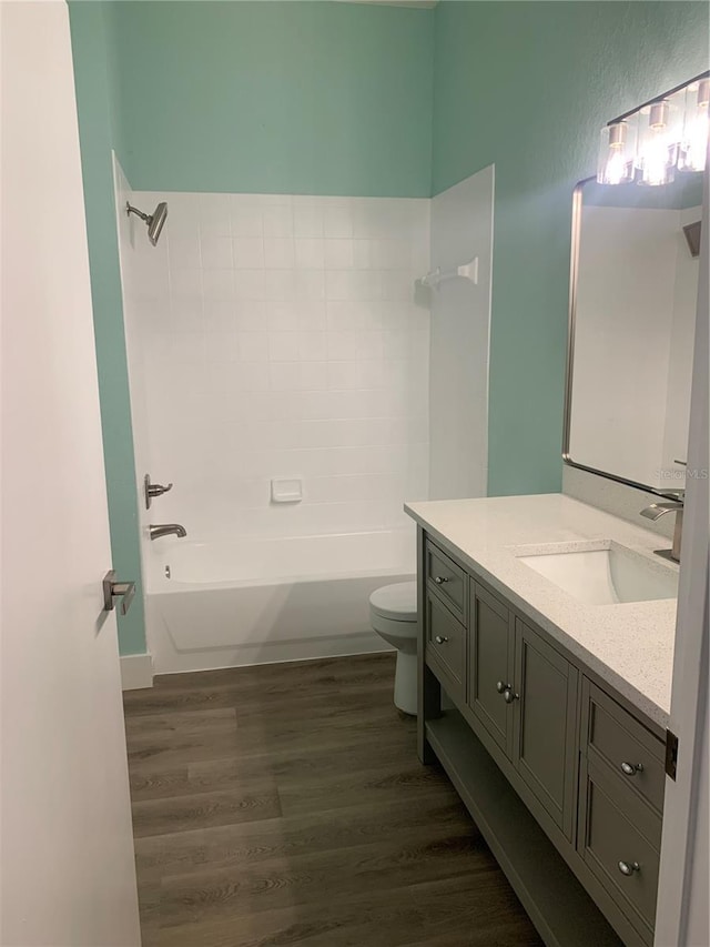 bathroom with tub / shower combination, vanity, toilet, and wood finished floors