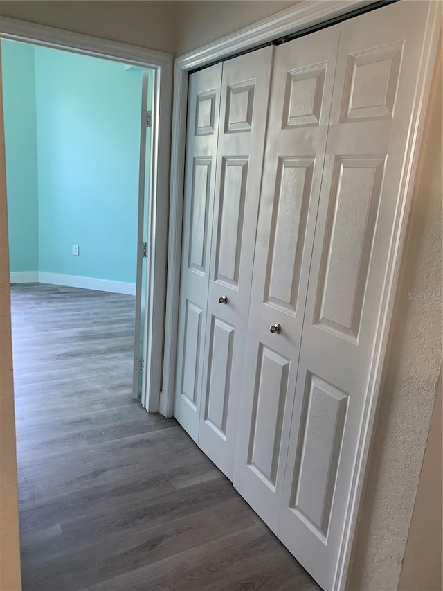 hall featuring baseboards and wood finished floors