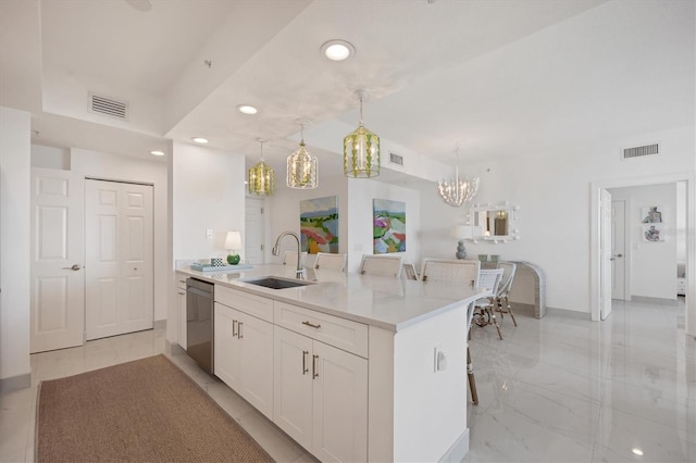 kitchen featuring sink, white cabinets, stainless steel dishwasher, and decorative light fixtures