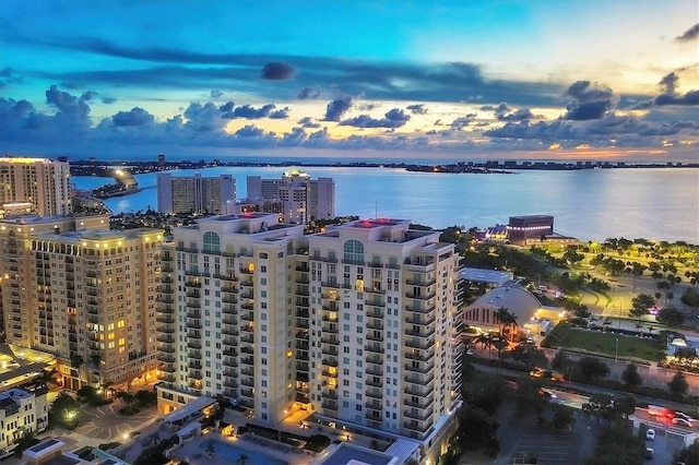 aerial view at dusk featuring a water view