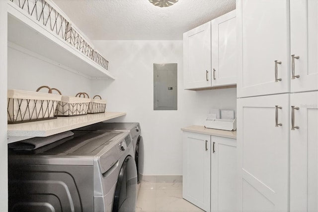 laundry area with cabinets, a textured ceiling, electric panel, and washing machine and clothes dryer