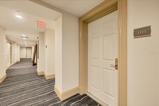 hallway featuring dark colored carpet