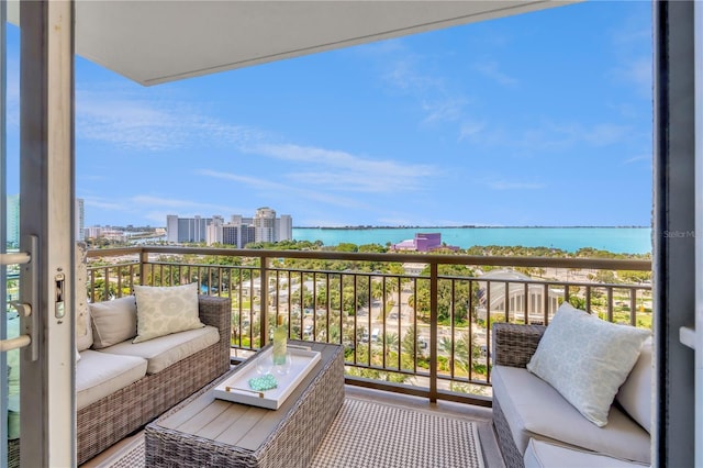 balcony with a water view and an outdoor hangout area