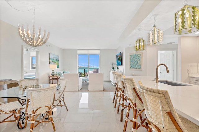 dining space featuring a notable chandelier and sink