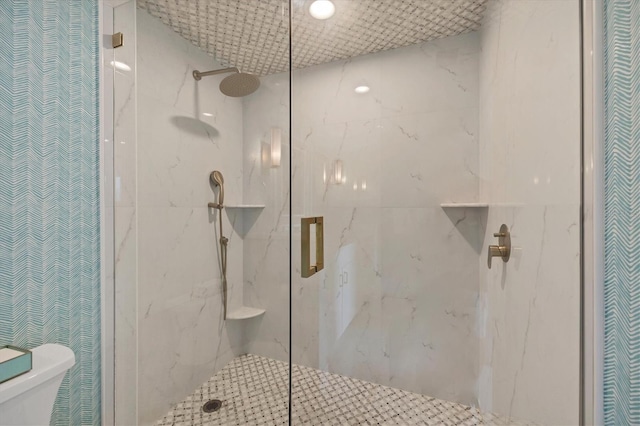 bathroom featuring toilet and a shower with shower door