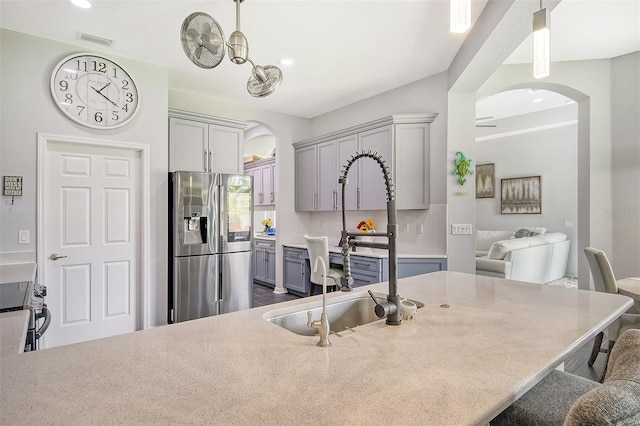 kitchen with gray cabinetry, decorative light fixtures, dark hardwood / wood-style floors, and appliances with stainless steel finishes